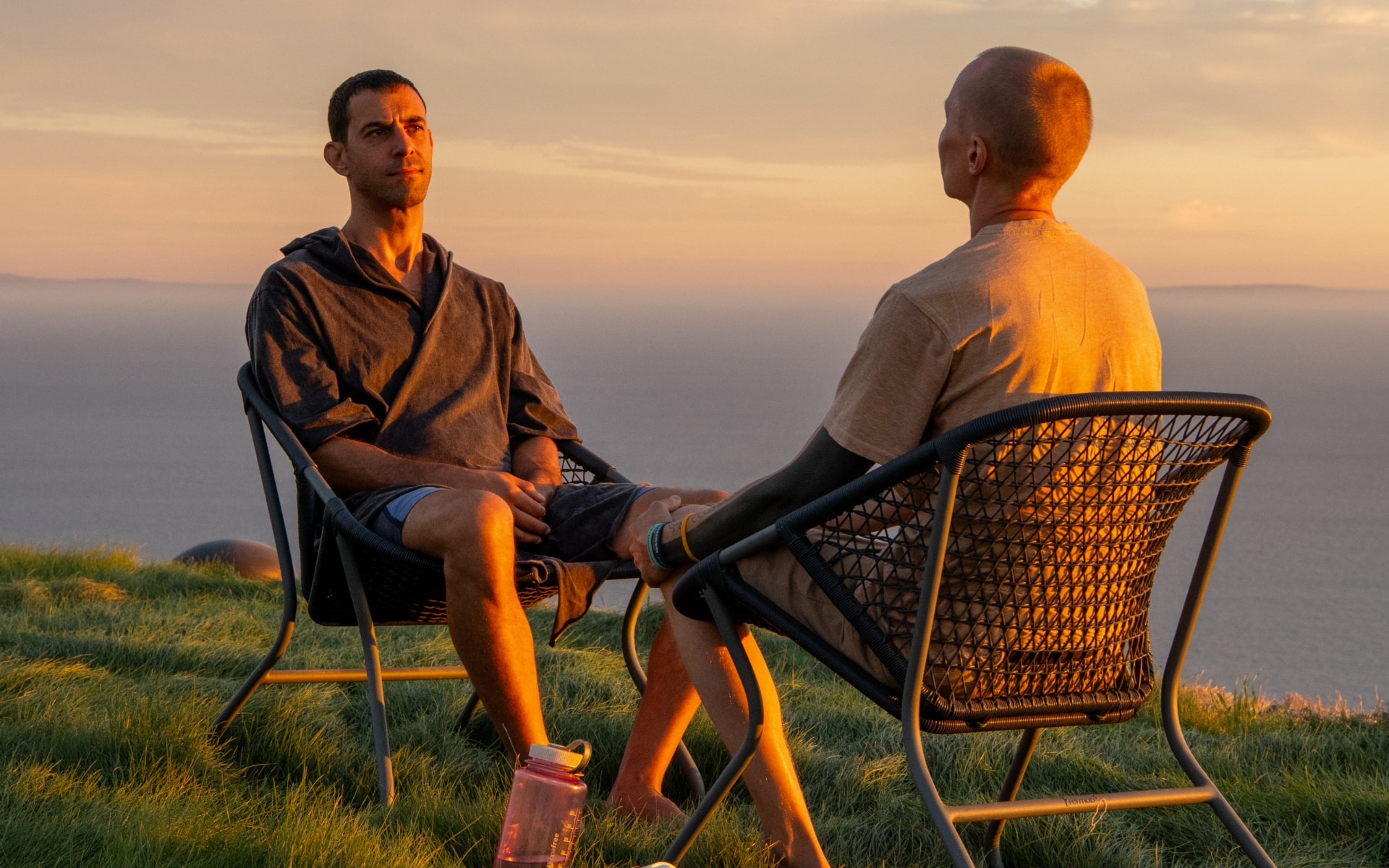 Nathanael in conversation on an ocean bluff at sunset